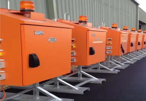 Row of orange dewatering control panels ready for dispatch